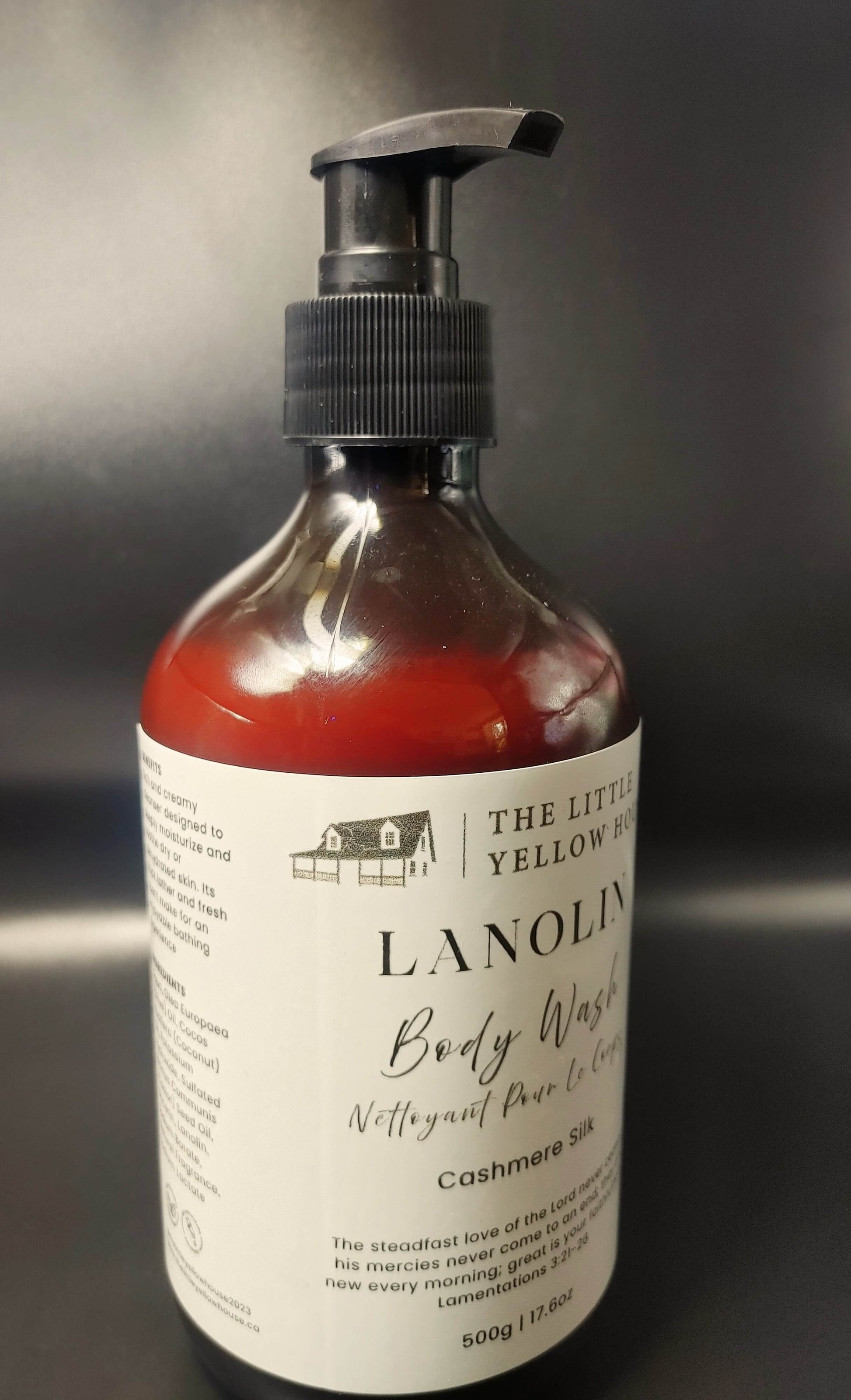 Bottle of cashmere silk  lanolin body wash with pump on a dark background